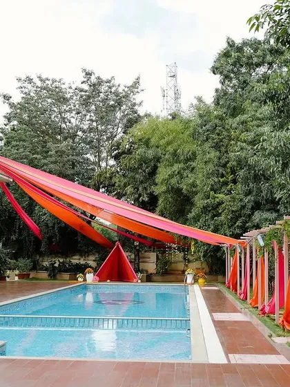 We transformed this poolside venue for a vibrant Haldi party. Bright orange and pink drapes were hung overhead, adding a festive canopy of color that reflected beautifully on the water.