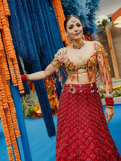 Shweta's full Mehendi look against the vibrant decor. The makeup, with its defined eyes and radiant base, stands out beautifully and complements the rich colors of her traditional attire.