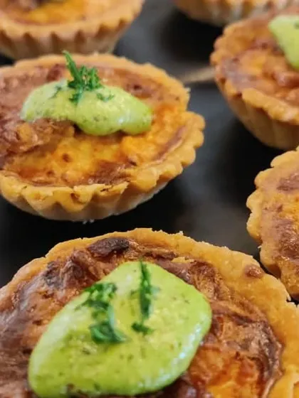 Mini Quiche Lorraine with a dollop of herb pesto. These savoury tartlets were served as a starter for an elegant corporate dinner, showcasing our classic European culinary skills.