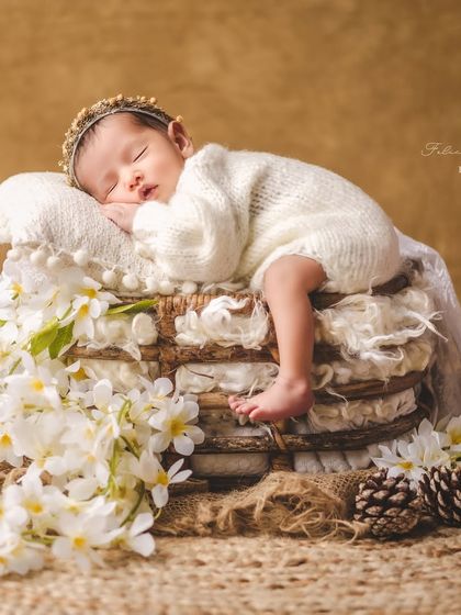 A precious new life surrounded by delicate white blossoms. I love incorporating natural elements like flowers to add a touch of organic beauty to my newborn portraits.