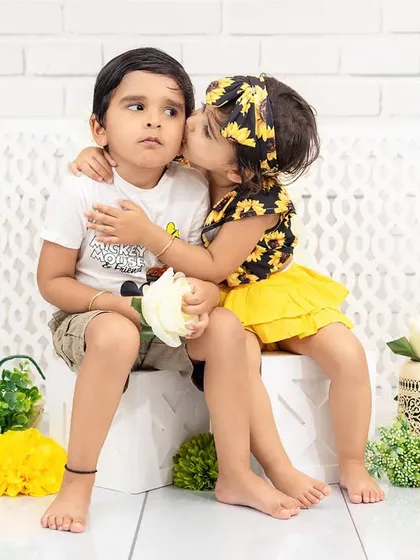 An incredibly sweet and unposed moment of sibling love. A little sister gives her brother an affectionate kiss on the cheek, a perfect example of the real, heartfelt interactions I aim to capture.