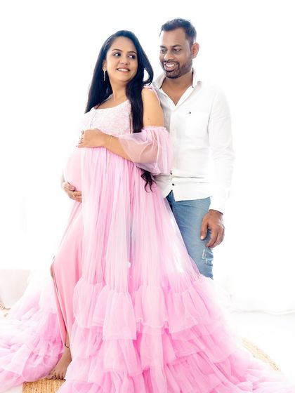 A beautiful portrait capturing a loving glance between a couple during their pink-themed maternity shoot.