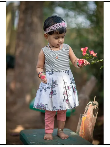 A toddler curiously touching a flower. These moments of natural exploration make for beautiful and authentic photographs.