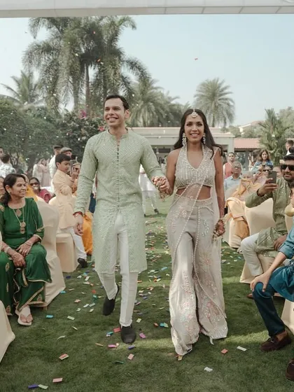 The couple making their entrance at the Haldi ceremony, walking hand-in-hand, ready for the celebrations to begin.
