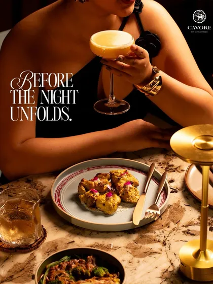 A perfect pairing to begin the night. A carefully crafted cocktail sits beside a plate of savory bites, setting the stage for the flavors and conversations that are yet to unfold.