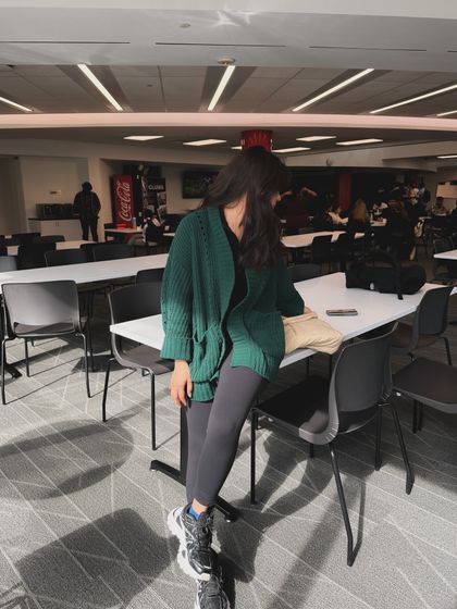A candid shot in a college cafeteria or library, showing the outfit in a real campus environment.