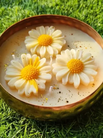 A hammered brass bowl filled with soy wax and topped with three beautiful daisy-shaped wax flowers.