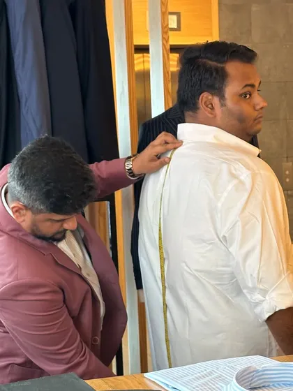 Taking precise measurements at our trunk show. We bring the full bespoke experience to you, ensuring a perfect fit no matter the location.
