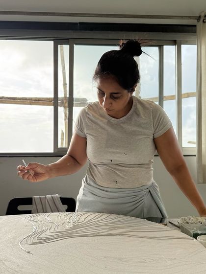 Hands at work, every stroke whispers an untold story. This is a moment of deep focus while creating "Cosmic Currents."