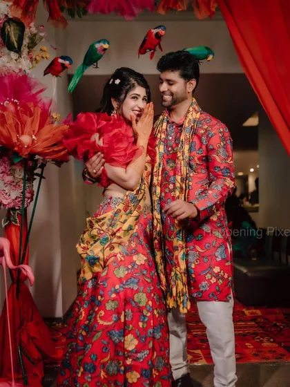 A happy moment between the couple, framed by our colorful Mehendi decor with hanging parrot props.