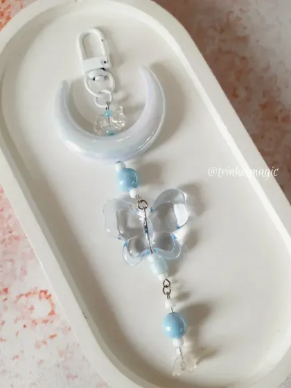The dreamy blue version of the moon and butterfly charm. The pastel blue beads and translucent butterfly create a serene and magical vibe.