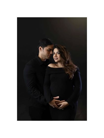 In the color version, the warmth and emotion are palpable. This studio maternity shoot captures the miracle of their journey, a quiet moment of connection before their family grows.