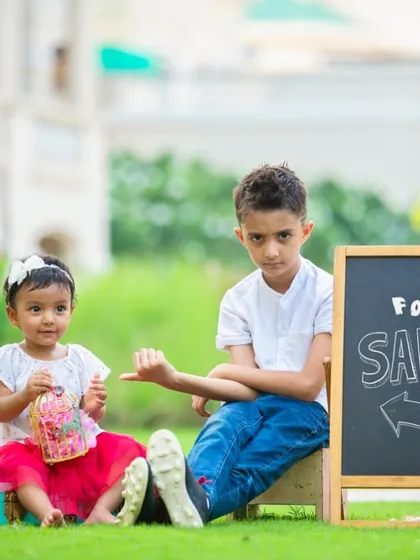 Sibling photoshoots are all about capturing their true personalities. This playful moment between a brother and his little sister, complete with a cheeky chalkboard sign, shows the fun and laughter we have during our sessions.