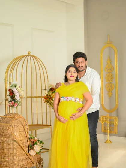 A beautiful, full-length portrait of an expecting mother and her partner in a bright and airy studio setting, celebrating this special time.