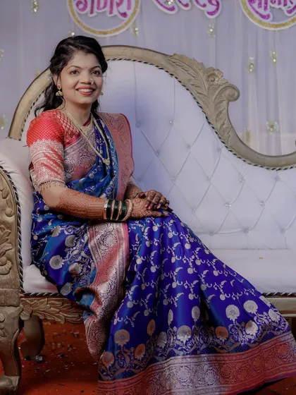 My engagement bride looking serene and beautiful on a classic sofa. The royal blue saree and simple makeup create a look of timeless elegance.