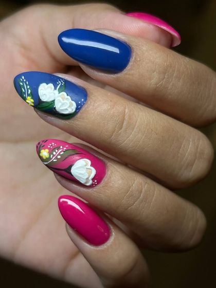 A bold and colorful floral nail art design. This set features a mix of solid blue and pink nails with accent nails showcasing beautiful, hand-painted 3D flowers.