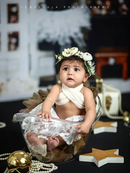 This wide shot shows the full 'Vogue' inspired setup, with a chic black and gold theme, pearls, and fashion props for a truly unique baby photoshoot.