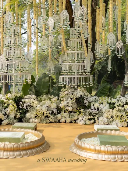 A stunning backdrop of hanging floral chandeliers made from delicate white flowers, creating a dreamy and fragrant setting for the Haldi rituals.