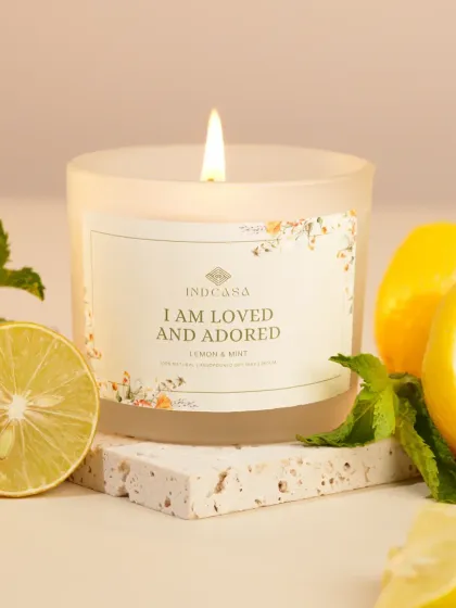 A bright and airy shot of a lemon and mint scented candle, styled with fresh lemons. Using ingredient props is a great way to visually communicate a candle's fragrance.