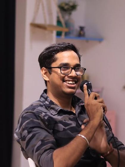 A performer from the "Aralikatte" family, smiling at the audience.