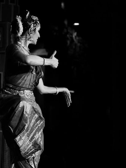 Another perspective in black and white, highlighting the form and line of the dance against the darkness.