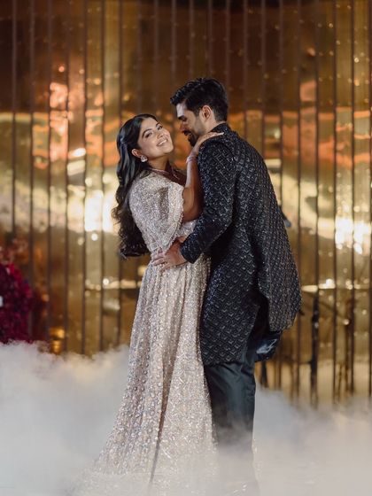 The couple shares a romantic dance, surrounded by theatrical smoke for a dreamy effect.
