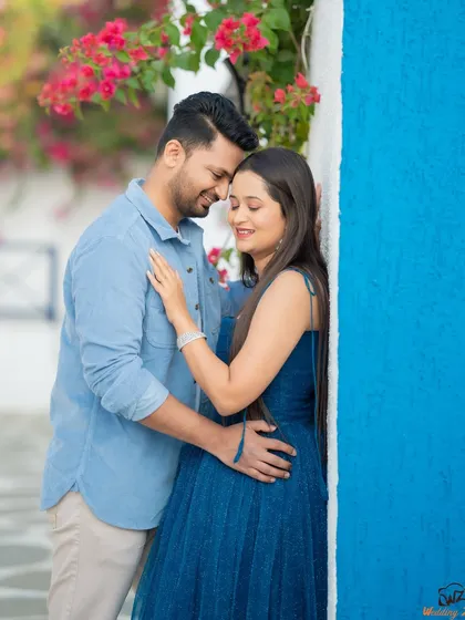 A pop of color makes this pre-wedding photo of Jui and Vaikrant stand out. The bright blue wall contrasts beautifully with their outfits, creating a vibrant, Santorini-like feel.