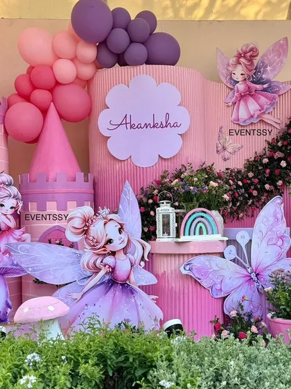 Close-up of the adorable fairy cutouts and pink castle, with balloon garlands adding a soft, dreamy touch.