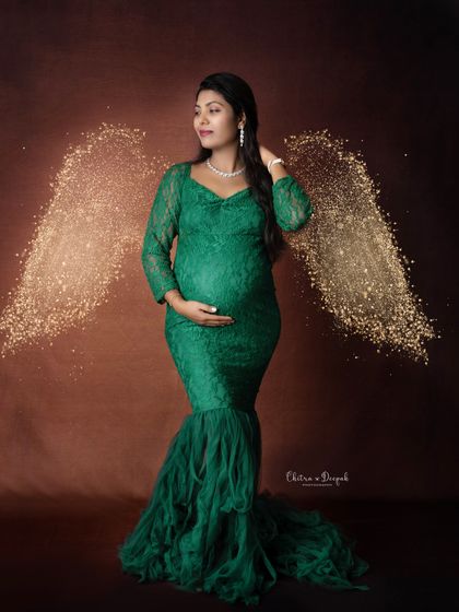A touch of gold. This mom-to-be looks like a forest angel in her green lace gown, complete with sparkling wings and a confident pose.