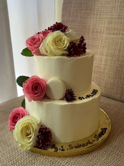 An elegant two-tiered engagement cake. This 2kg chocolate sponge cake with dark chocolate ganache is decorated with a beautiful arrangement of fresh pink and white roses.