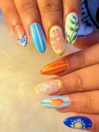 This playful, summery set features different hand-painted designs on each nail. We included citrus slices, stripes, leaves, and even a tiny goldfish for a fun and unique manicure.
