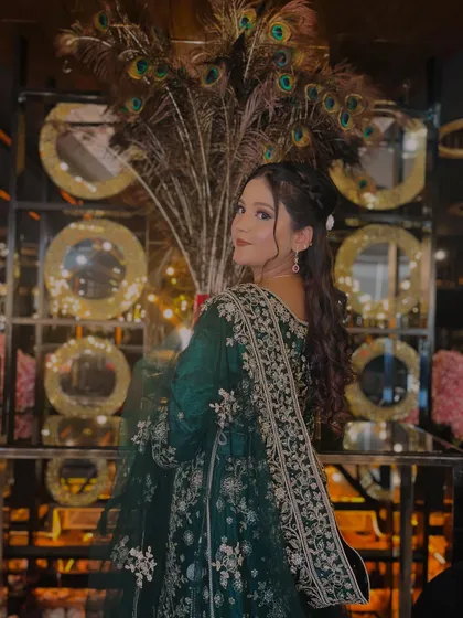 Perfect for a sangeet or reception, this glamorous party look features an elegant emerald green outfit. The makeup is soft yet defined, with a focus on glowing skin and a romantic hairstyle, ensuring you look stunning from every angle.
