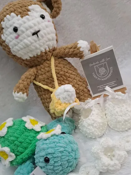 A wonderful custom gift set including a monkey doll, a plush turtle, and a full baptism accessory set with pearl-studded booties and a headband.