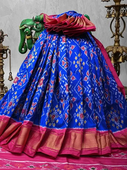 The vibrant energy of an Ikkat weave is unmatched. This pure silk Patola saree in royal blue and brilliant pink showcases the geometric precision of the Ikkat dyeing technique. The rich gold zari border adds a touch of festive grandeur, making it a true showstopper.