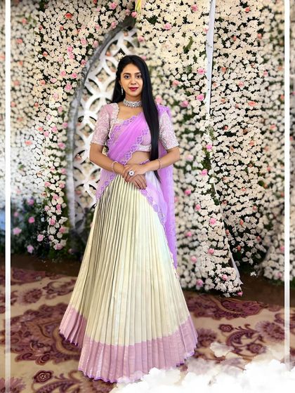 This lehenga is a beautiful blend of soft pastels. A silver and lilac hand-embroidered blouse is paired with an ivory and pink pleated Kanchi silk skirt, creating a look that is both elegant and vibrant.