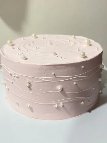 A simple and elegant pink cake decorated with delicate sugar pearls. This minimalist design is perfect for any occasion.