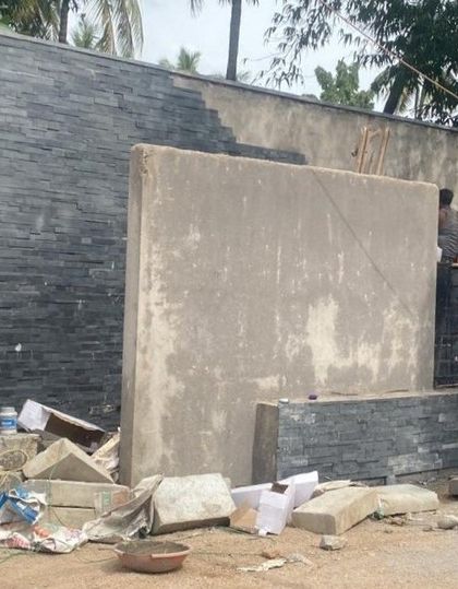 An identical view of the wall construction, showing the detailed work of laying the stacked stone.