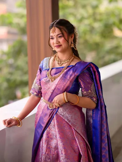 A full shot of the South Indian bride posing on a balcony, showcasing the entire elegant ensemble.