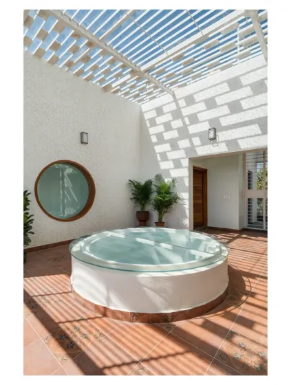 This terrace lounge is designed around the interplay of light, shadow, and geometry. A pergola casts dynamic patterns across the floor, while a circular skylight adds a unique architectural element, making this a special place to unwind.