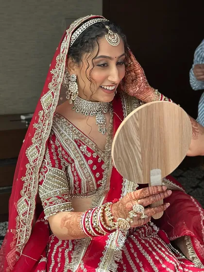That happy smile when she sees her final bridal look. Her makeup is soft and radiant, designed to enhance her natural curls and beautiful smile.