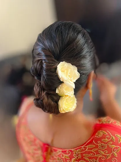 A beautiful braided bun with a touch of yellow flowers. This is a lovely style for a pre-wedding function.