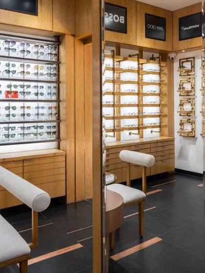 Reflective mirrors add depth and intrigue, enhancing the overall ambiance of the retail space. The design seamlessly fuses sleek architectural elements with organic textures.