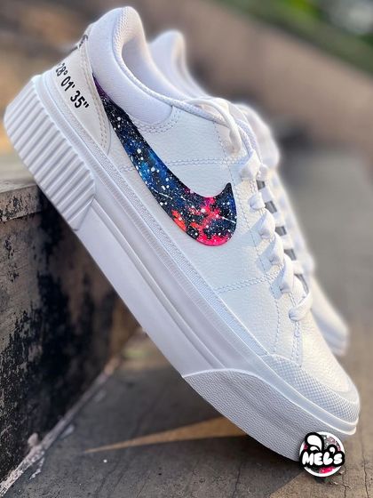 A side view of our cosmic-themed Nike sneakers, featuring a beautifully painted galaxy swoosh with pink and blue nebulas.