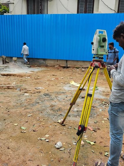 A surveyor at work on one of our sites. Precision is key from day one, and my turnkey process involves meticulous planning and site-marking before any construction begins.