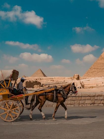 A horse-drawn carriage makes its way along a road at the Giza complex, offering a different perspective on travel around the ancient site.