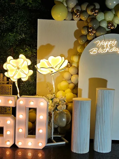 Celebrating a 50th birthday calls for something special and elegant. This setup features a classy white and gold theme with marquee numbers, a custom neon sign, and soft lighting to create a sophisticated atmosphere.