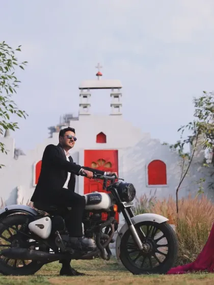 A unique, filmy-style outdoor maternity shoot featuring a couple with a Royal Enfield motorcycle. This shows how we can create a concept that is different and reflects your personality.