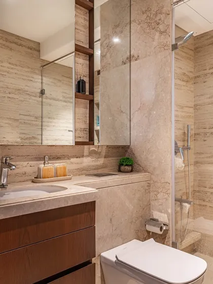 The master bathroom is a spacious retreat with luxurious brown marble throughout. Sleek mirrored cabinets provide ample storage, ensuring a clean, clutter-free, and sophisticated space.