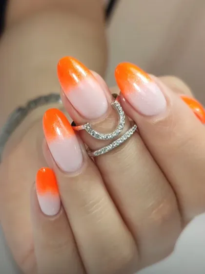 A bright and cheerful orange-to-white ombré on oval nails, perfect for a summer-ready manicure.