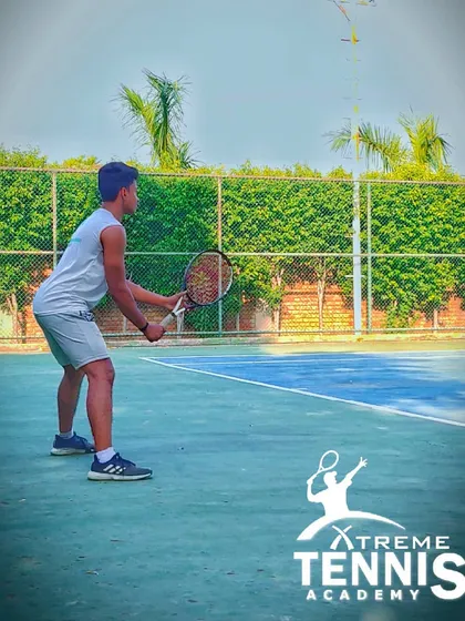 Focus is key. This player is locked in, ready to return a serve. We train our players to develop intense concentration to read the game and anticipate the opponent's next move.